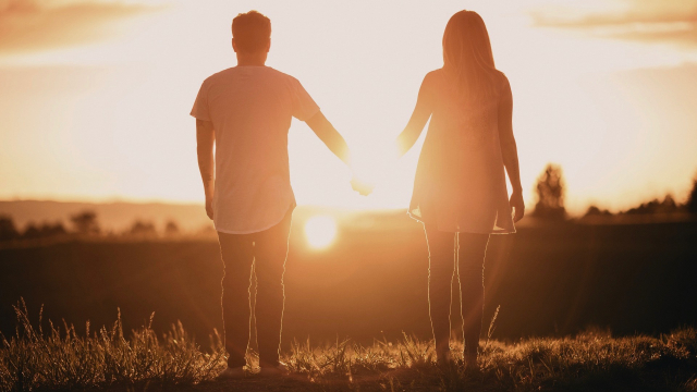 couple_holding_hands_sunset