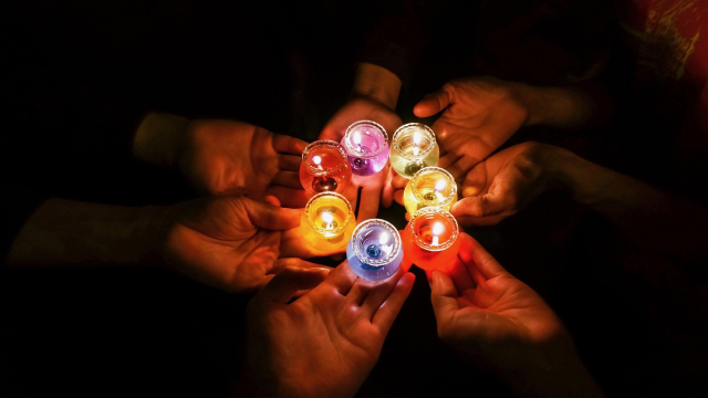 holding_multi-coloured_candles_hands