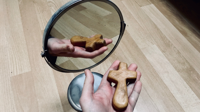 mirror_reflection_holding_cross